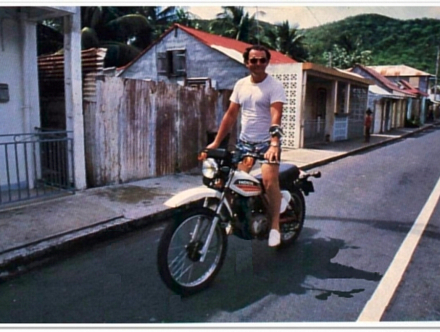 Coluche faisant de la moto en Guadeloupe
